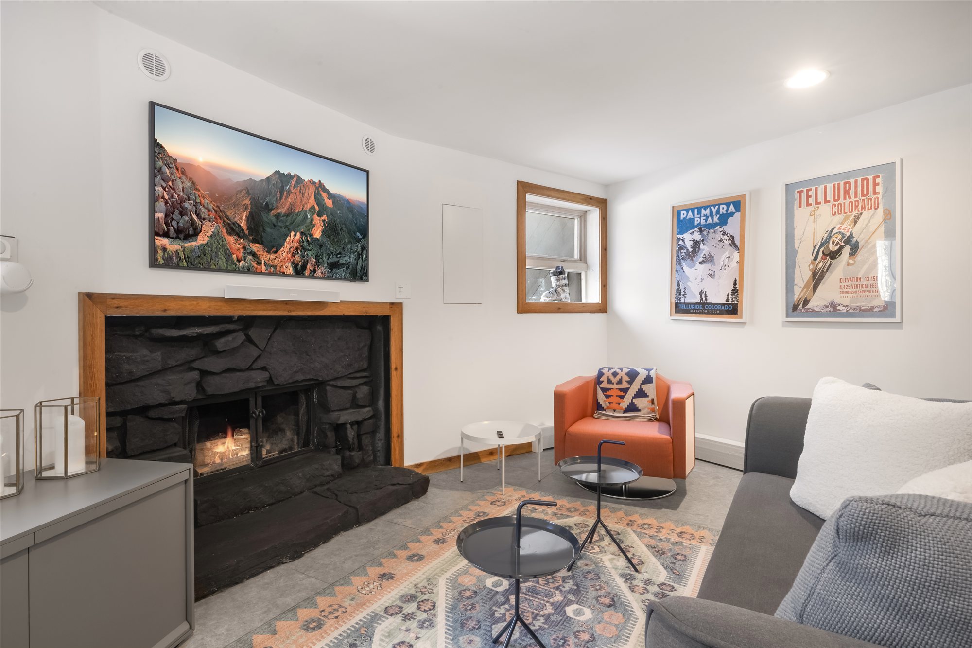 The den with sofas and a wall-mounted TV above the fireplace