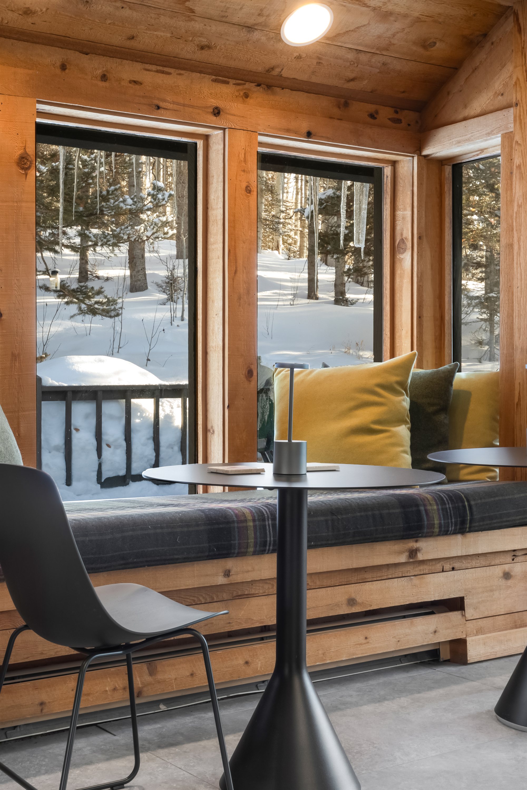 Cushioned window nook with café tables just off the kitchen