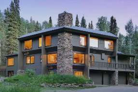 The lodge at dusk, windows glowing against a lavender sky
