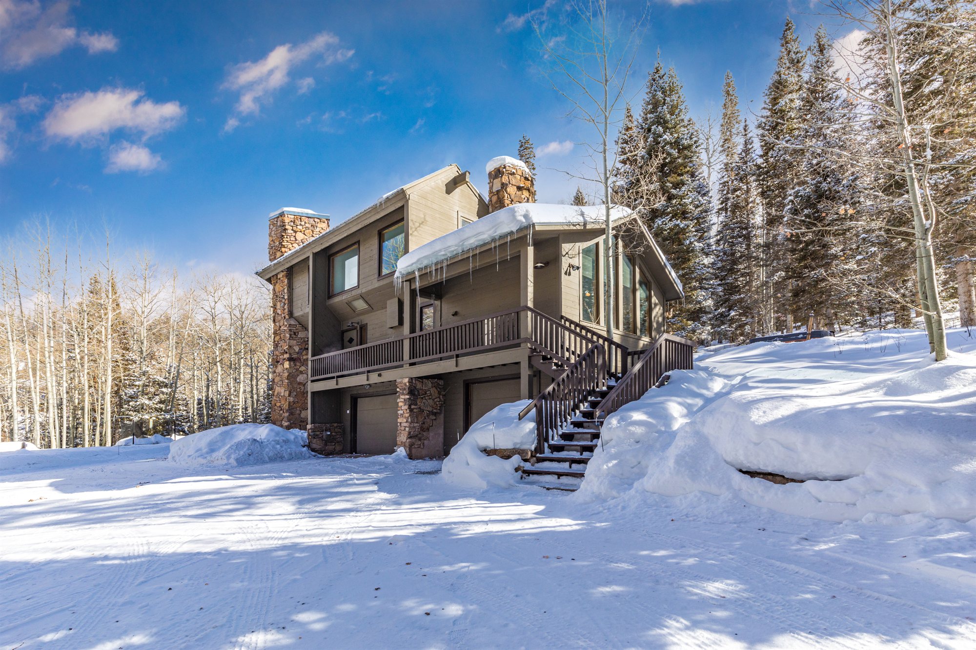The lodge from the drive, deep snow and stone chimney