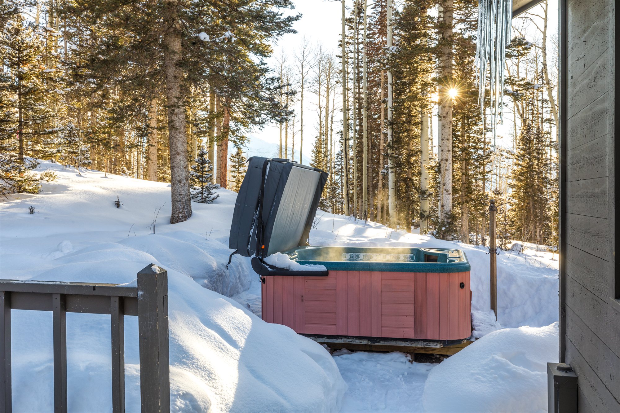 The hot tub banked in deep snow, aspens and pines all around