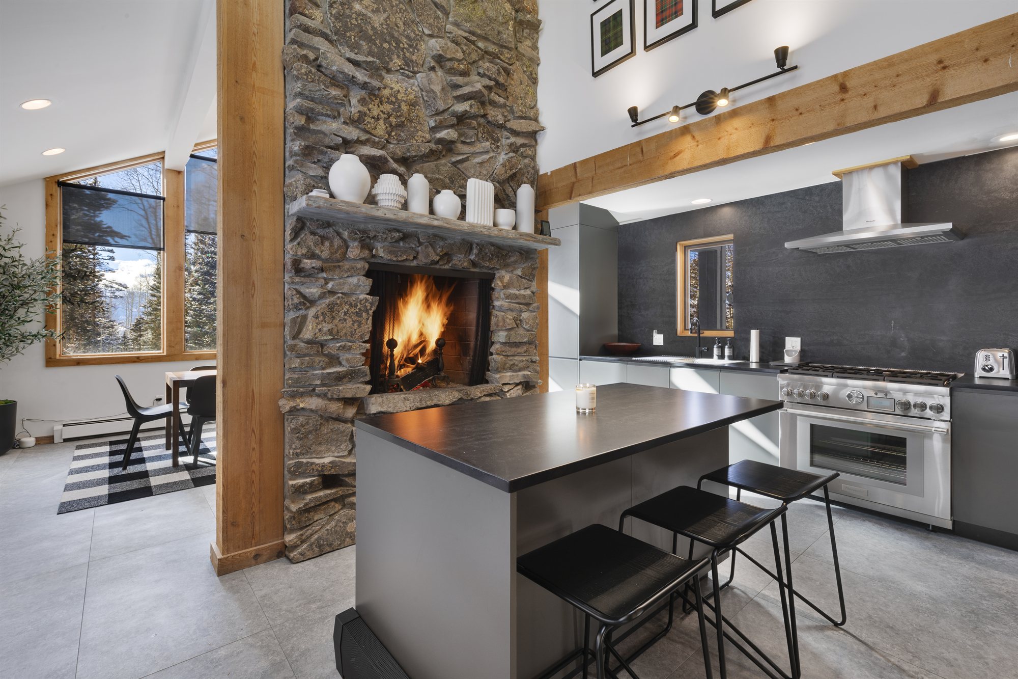 The kitchen with a fire lit beside the range and island seating
